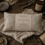 Load image into Gallery viewer, Karsten &amp; Co. organic lavender eye pillow on a wooden surface with lavender flowers and bottles.
