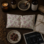 Load image into Gallery viewer, Floral eye pillow, lavender, and other items on a wooden surface with a warm ambiance.

