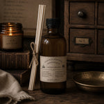 Load image into Gallery viewer, Brown bottle with label and reed diffuser on a wooden surface with vintage decor
