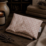 Load image into Gallery viewer, Folded fabric heat pillow with floral pattern on a wooden surface with lavender and books.
