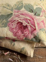 Load image into Gallery viewer, Floral fabric lavender heat pillow with pink roses and green leaves on a wooden surface
