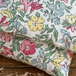 Load image into Gallery viewer, details of Floral fabric with pink, yellow, and blue flowers on a wooden surface
