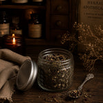 Load image into Gallery viewer, Glass jar of organic herbal tea on a wooden surface with a candle and book in the background - Karsten &amp; Co. Australia
