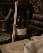 Load image into Gallery viewer, Vintage-style apothecary bottle with reeds and a mortar and pestle on a wooden surface.
