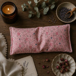 Load image into Gallery viewer, Floral eye pillow on a wooden surface with a lit candle, lavender, and dried flowers.
