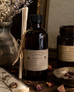 Load image into Gallery viewer, A bottle of 'Chandler 4 Corners' rose garden fragrance with reeds and dried flowers on a rustic surface.
