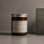 Load image into Gallery viewer, Pure Essential Oil Candle jar with a label on a concrete surface and grey background
