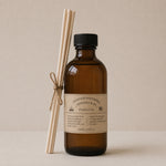 Load image into Gallery viewer, Brown bottle reed diffuser with black cap and wooden sticks on a beige background
