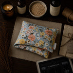 Load image into Gallery viewer, Floral lupin heat pack/pillow on a textured surface with candles, bottles, and notes - karsten &amp; Co. Australia
