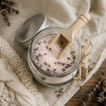 Load image into Gallery viewer, Glass jar of organic lavender bath salt with a wooden scoop on a soft fabric - handmade in Australia by Karsten &amp; Co
